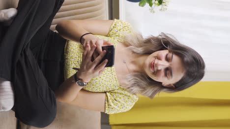 Vertical-video-of-Young-woman-texting-with-happy-expression.